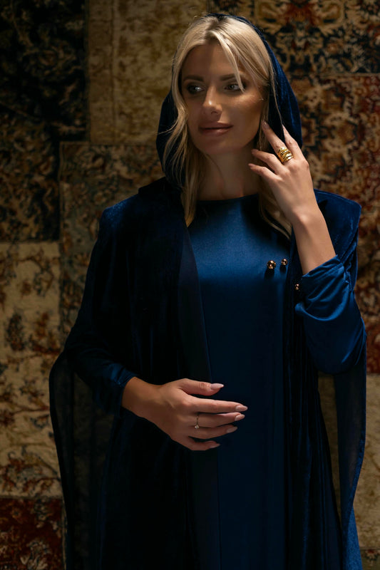 model wearing blue dress with cape in Andalusian decor
