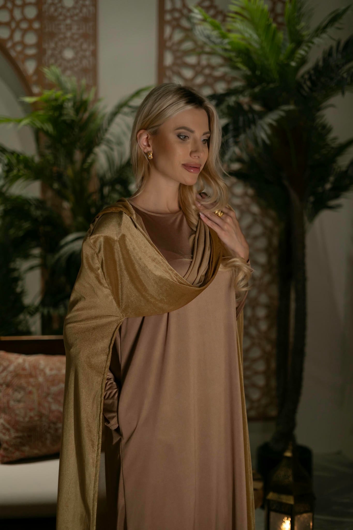 model wearing gold dress with cape in andalusian decor
