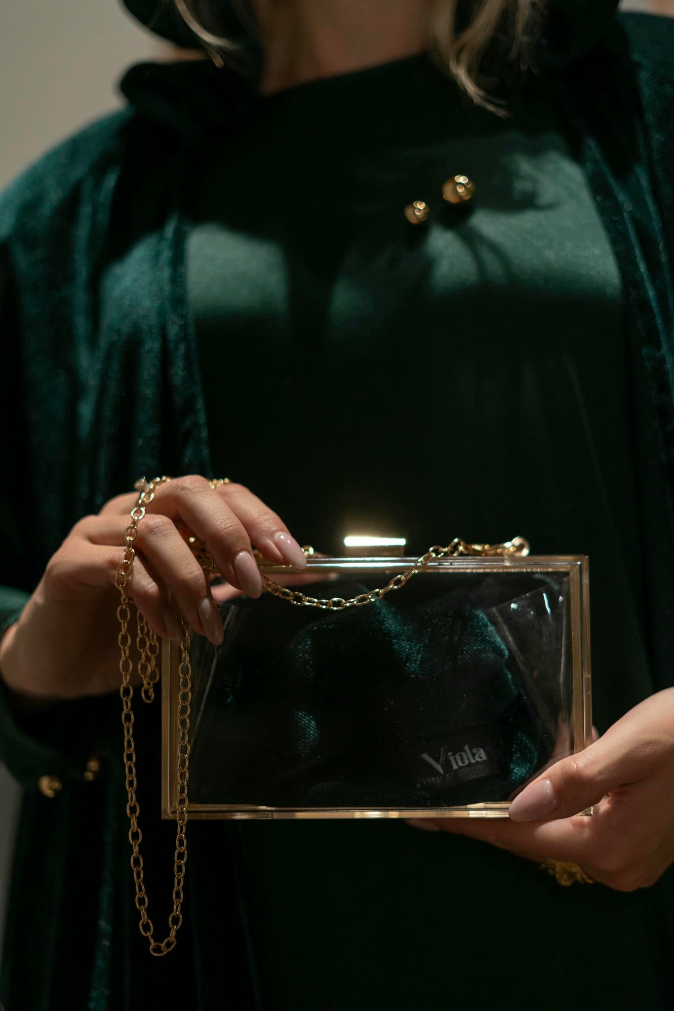 model wearing green dress with cape in Andalusian decor and holding bag