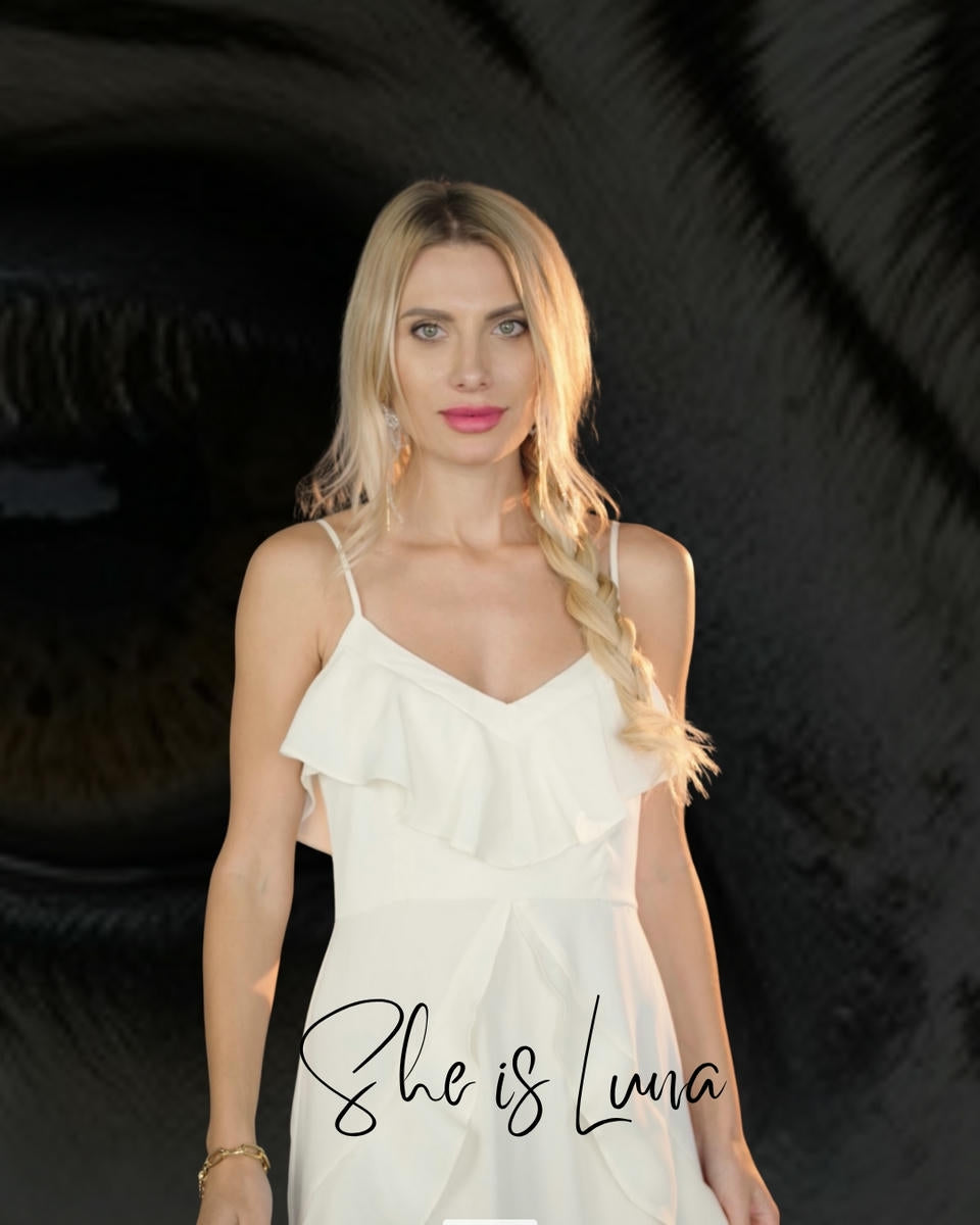 Woman wearing a white dress with 'She is Luna' text on a dark background
