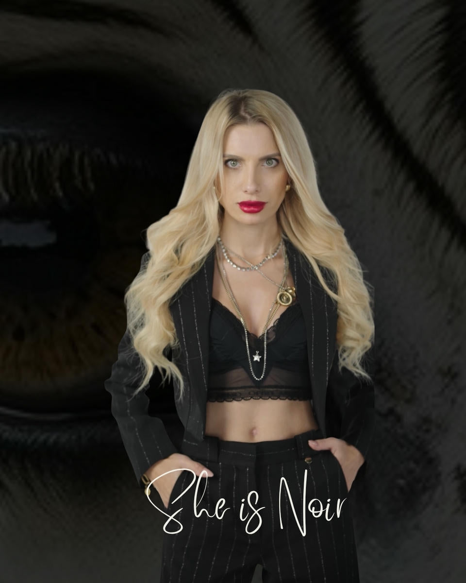 Woman in a black outfit with 'She is Noir' branding against a dark background