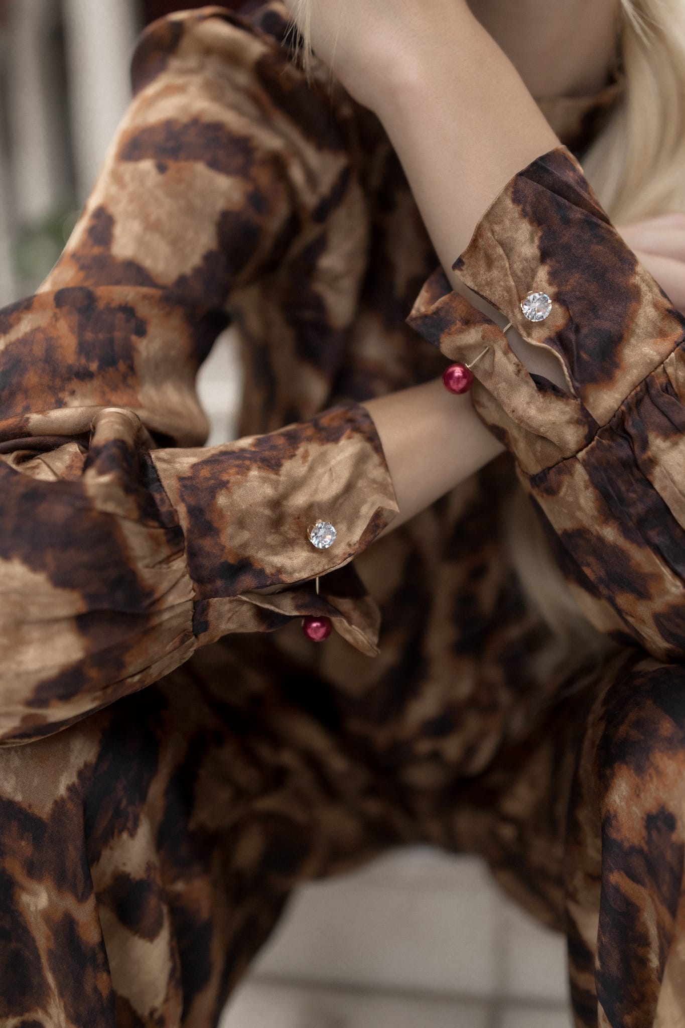 Close-up of a model wearing a leopard print outfit with decorative buttons.