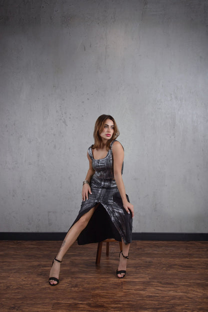 Woman in a metallic dress posing against a gray wall.