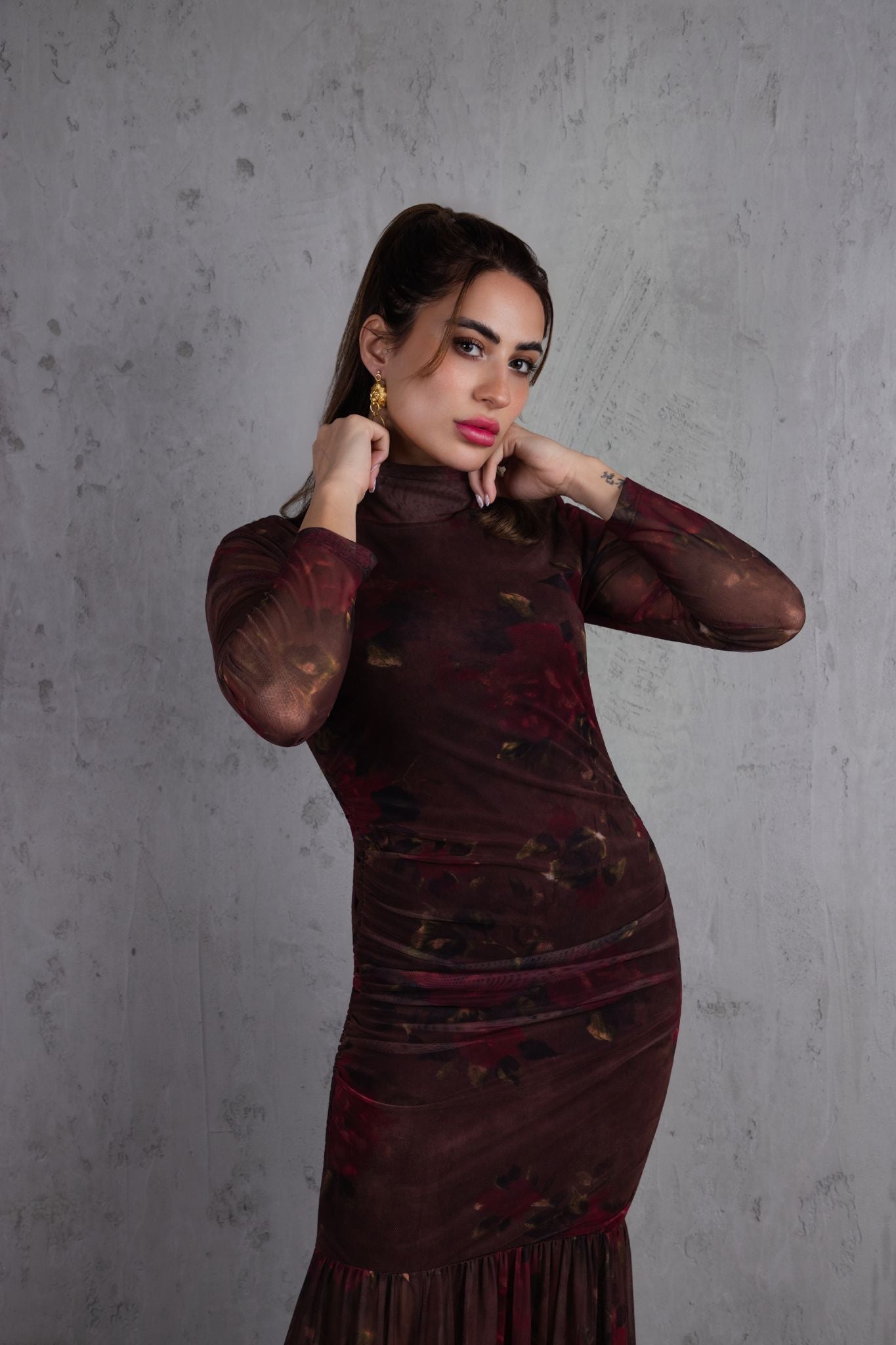 Woman wearing a dark red dress against a gray background