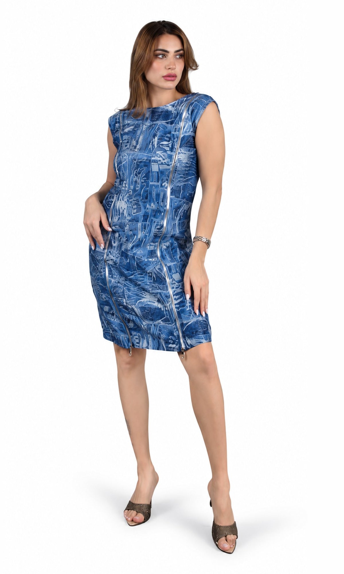 A woman modeling a sleeveless blue and white abstract patterned dress with side pockets, paired with brown heeled sandals, against a plain white background.