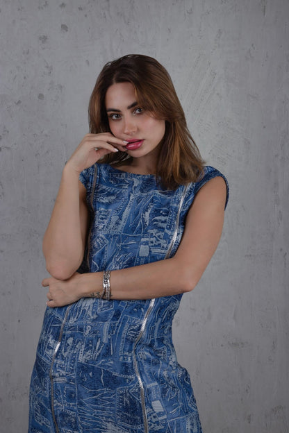 Woman wearing a blue patterned dress against a gray background