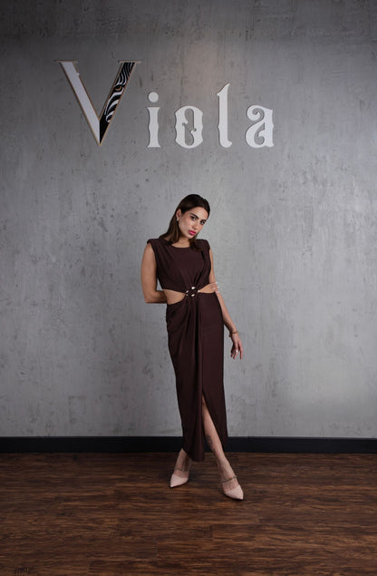 Woman in a brown dress standing against a gray wall with 'Viola' branding.