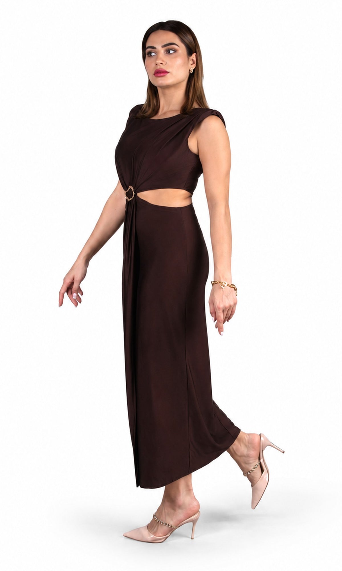 A woman modeling a dark brown, one-shoulder midi dress with a side cutout and a gold ring accent, paired with nude high-heeled sandals against a plain white background.
