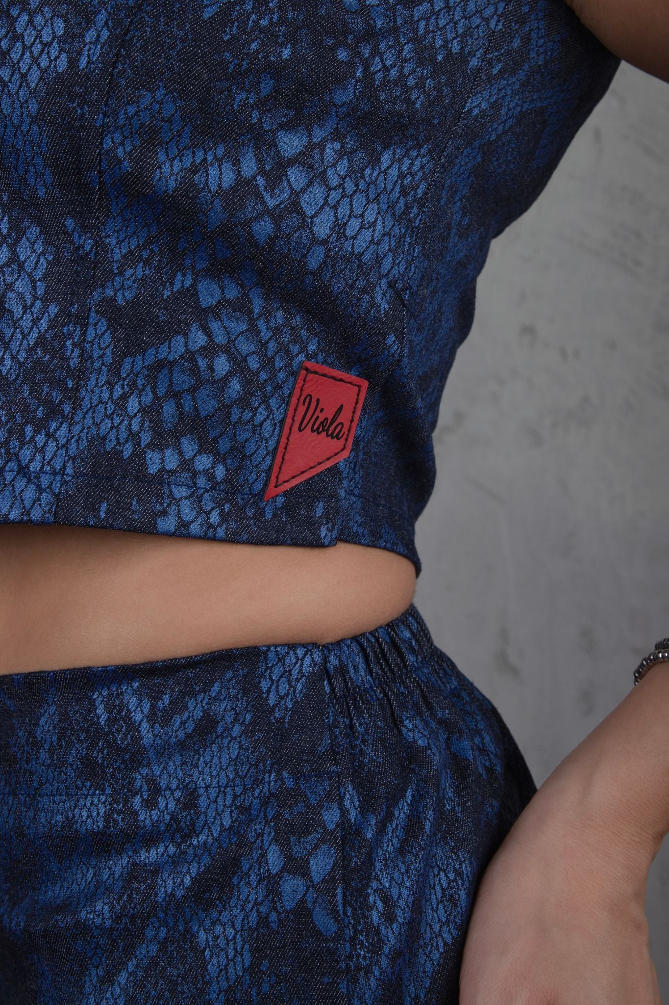 Blue patterned top with a red label on a neutral background