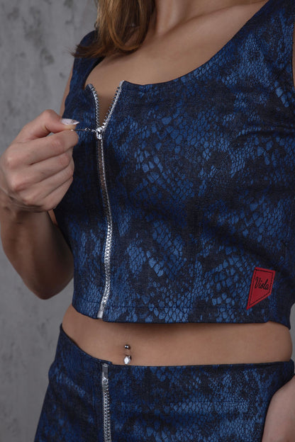 Blue patterned top with a zipper and brand logo on a blue denim background