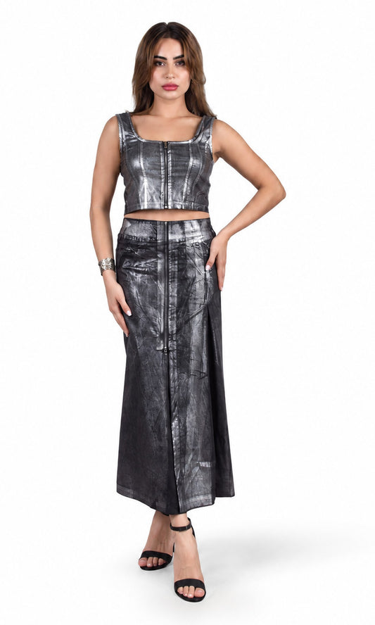 A woman modeling a two-piece metallic silver two-tone crop top and midi skirt set with a tie-dye pattern, paired with black strappy heels, against a plain white background.