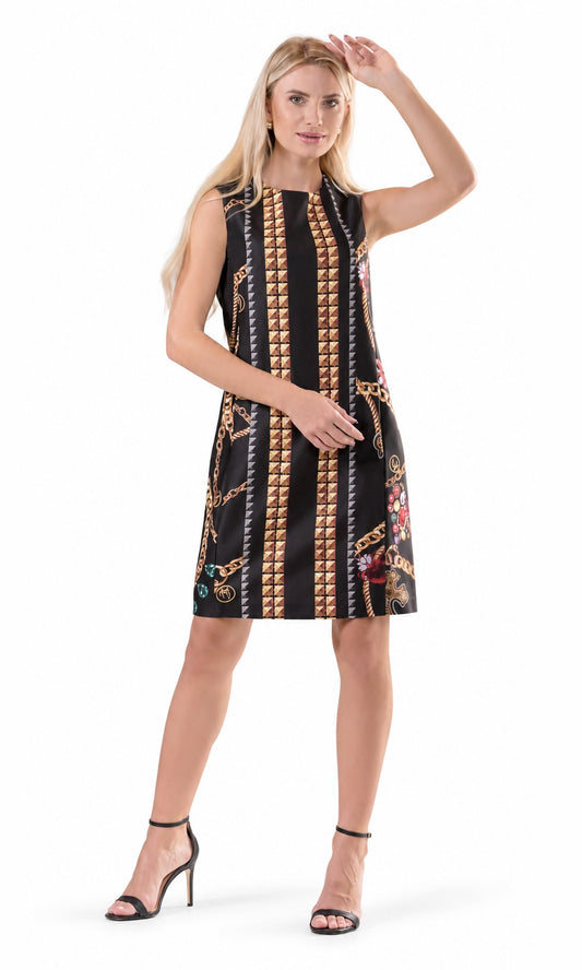 A woman modeling a sleeveless black A-line dress with vertical gold chain and coin-like patterns, shown against a plain white studio background.