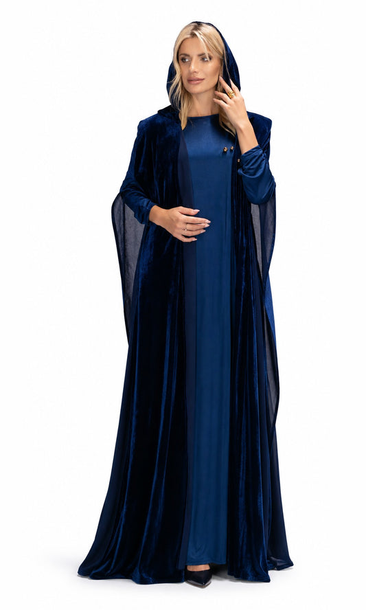 A woman modeling a long, floor-length navy blue gown with a matching sheer hooded cloak, photographed against a plain white studio background.