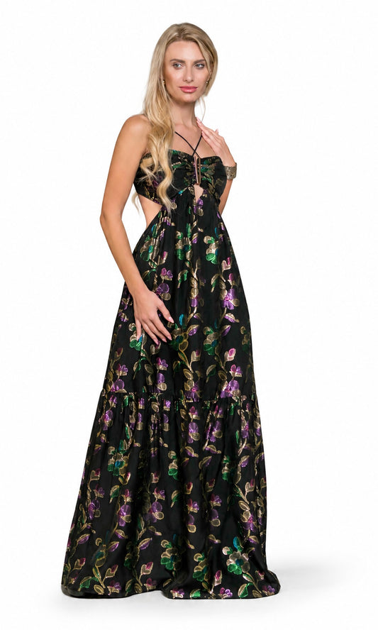 A blonde model wearing a black strapless maxi dress with a tiered skirt and a vibrant floral pattern in purple, green, and gold, posed against a plain white studio background.