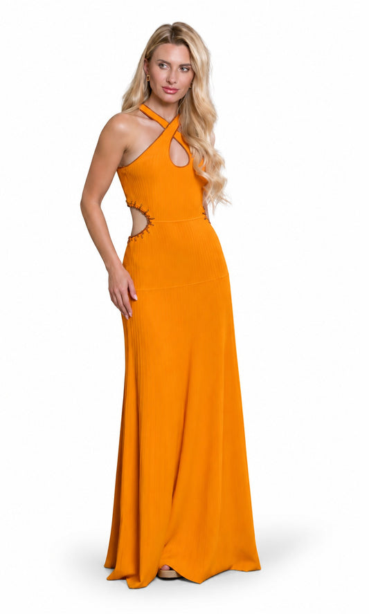A blonde model wearing a bright orange halter-neck maxi dress with side cutouts, standing against a plain white background.
