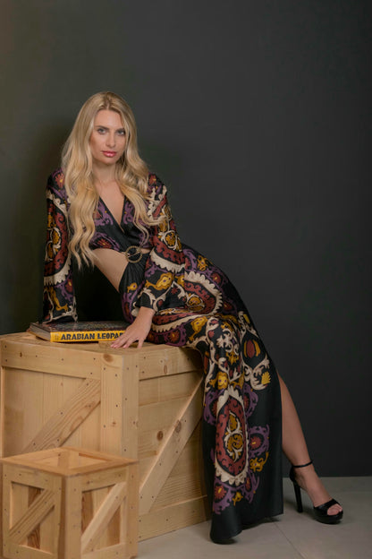 model wearing a maxi print dress with side slit and cut out waist