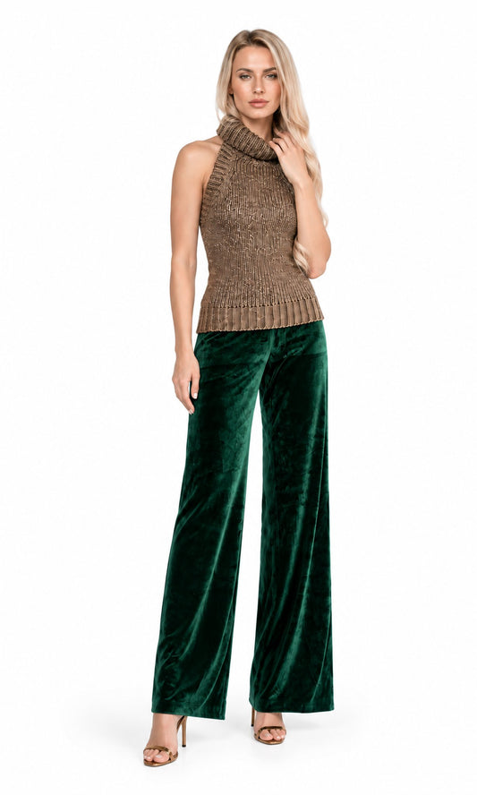 A woman modeling a sleeveless brown knit mock-neck top paired with dark green velvet wide-leg pants, standing against a plain white background.